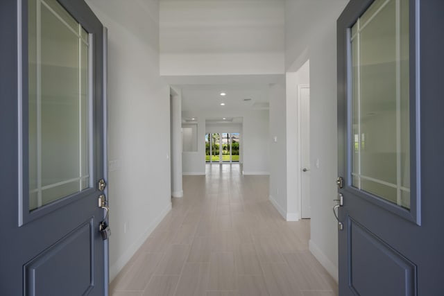 foyer with baseboards and recessed lighting