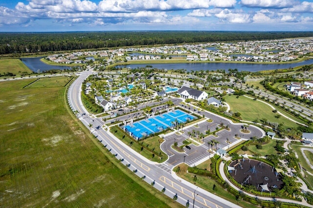aerial view of property and surrounding area with a nearby body of water and nearby suburban area