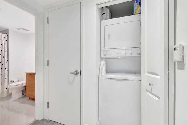 480 Hibiscus St Unit 709, West Palm Beach, FL 33401 - clothes washing area with stacked washing machine and dryer and light tile patterned flooring