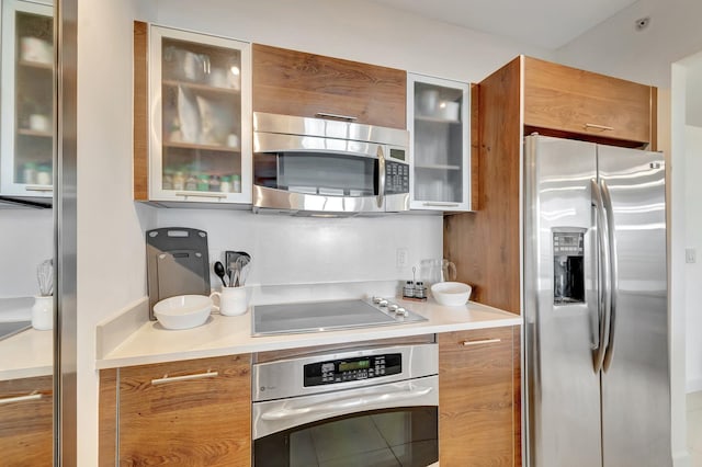 480 Hibiscus St Unit 709, West Palm Beach, FL 33401 - kitchen featuring appliances with stainless steel finishes, brown cabinets, modern cabinets, and light countertops