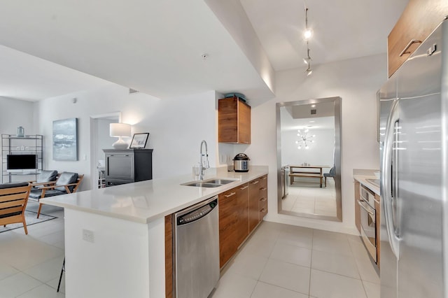 480 Hibiscus St Unit 709, West Palm Beach, FL 33401 - kitchen featuring stainless steel appliances, a sink, modern cabinets, brown cabinetry, and a peninsula