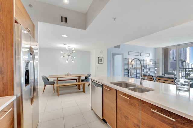 480 Hibiscus St Unit 709, West Palm Beach, FL 33401 - kitchen featuring appliances with stainless steel finishes, a sink, light countertops, light tile patterned flooring, and brown cabinets