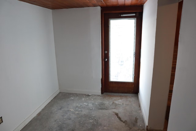 spare room with concrete floors, wooden ceiling, and baseboards