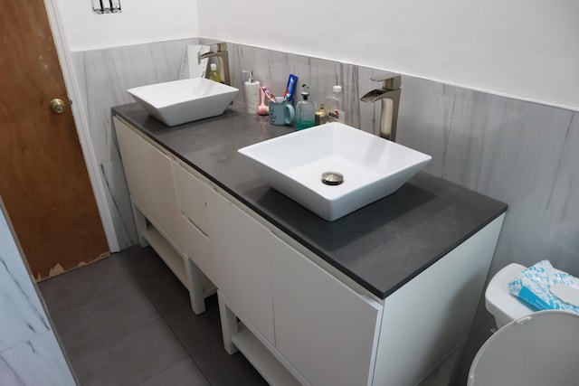 bathroom featuring double vanity, tile patterned flooring, and toilet