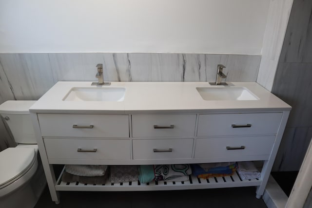 full bathroom with double vanity and toilet