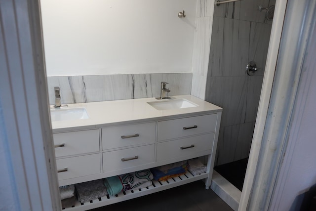 bathroom with a shower, tile patterned flooring, double vanity, and tile walls
