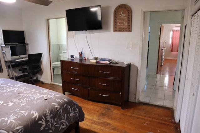 bedroom featuring ensuite bath and wood finished floors