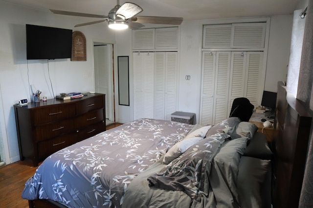 bedroom with multiple closets, wood finished floors, and ceiling fan
