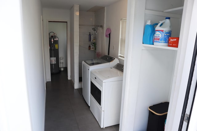 washroom featuring washer and clothes dryer, water heater, and tile patterned flooring