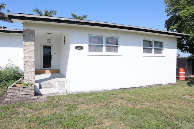 view of front of property featuring stucco siding and a front lawn
