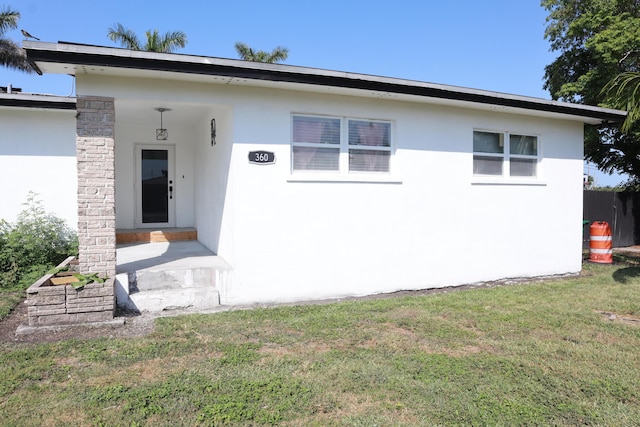 view of front of property with stucco siding and a front lawn