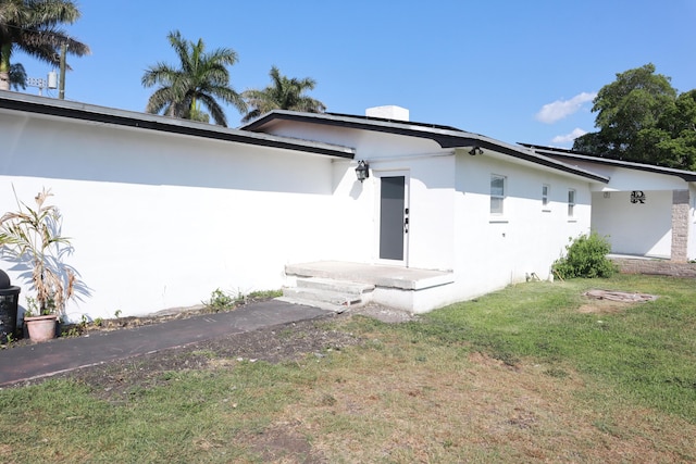 view of front of home featuring stucco siding and a front lawn