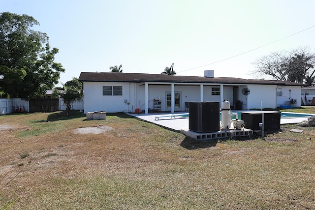 back of house with central AC unit and stucco siding