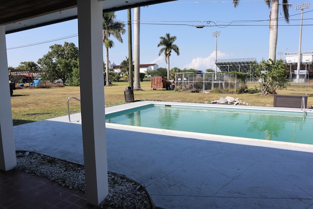 outdoor pool featuring a yard