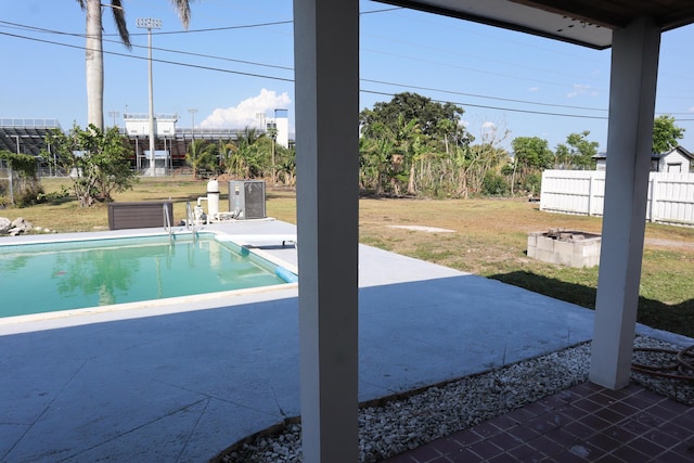 swimming pool with a patio, a diving board, and an outdoor fire pit
