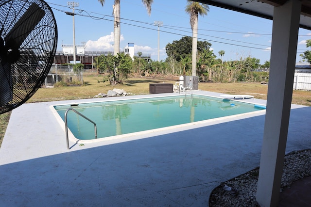 outdoor pool featuring a patio area and fence