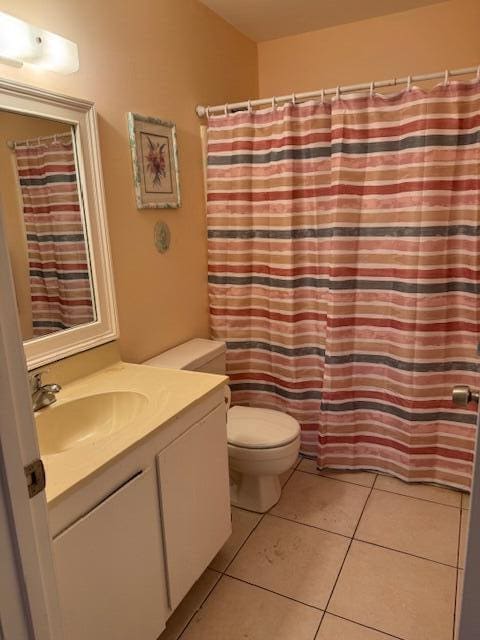4065 NW Cinnamon Tree Cir, Jensen Beach, FL 34957 - bathroom featuring tile patterned floors, toilet, vanity, and a shower with curtain