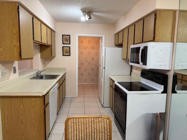 4065 NW Cinnamon Tree Cir, Jensen Beach, FL 34957 - kitchen with white appliances, a sink, a textured ceiling, light countertops, and light tile patterned floors