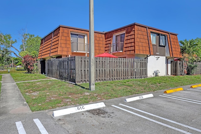 view of property with a fenced front yard and uncovered parking