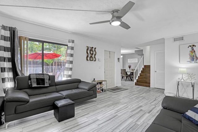 living room featuring ceiling fan, wood finished floors, and stairs