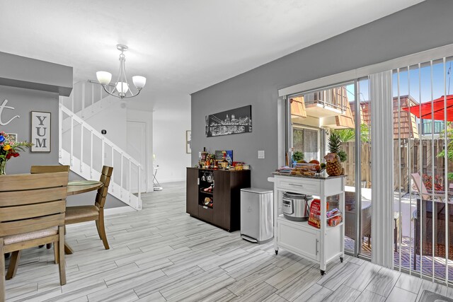 dining room featuring stairs, a chandelier, and light wood-type flooring