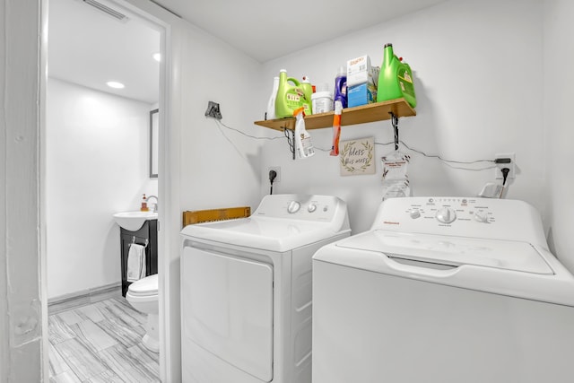laundry room featuring washing machine and clothes dryer and marble finish flooring
