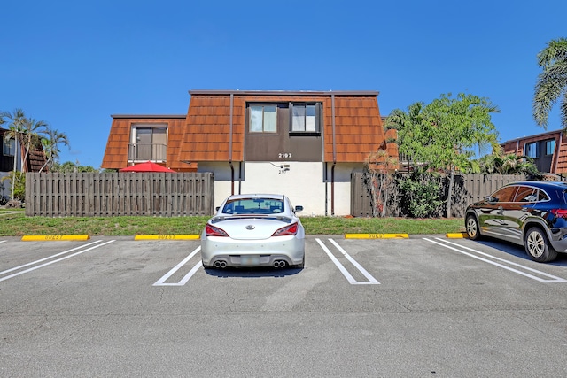 uncovered parking lot featuring fence
