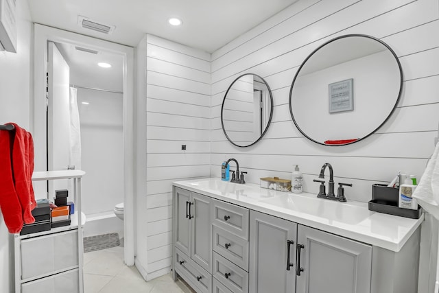 full bath featuring tile patterned floors, double vanity, a shower with shower curtain, wooden walls, and toilet