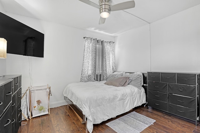 bedroom featuring dark wood finished floors, a ceiling fan, and baseboards