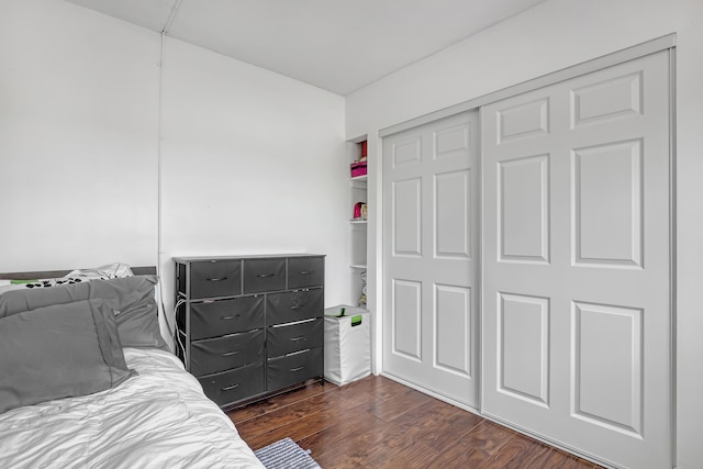 bedroom with dark wood-type flooring and a closet