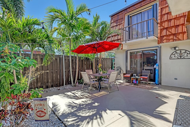 view of patio / terrace with outdoor dining space, a balcony, and fence