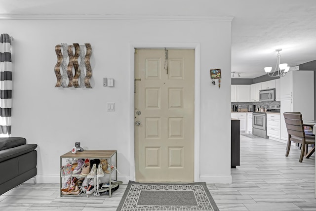 entryway with baseboards, a chandelier, ornamental molding, and wood tiled floors