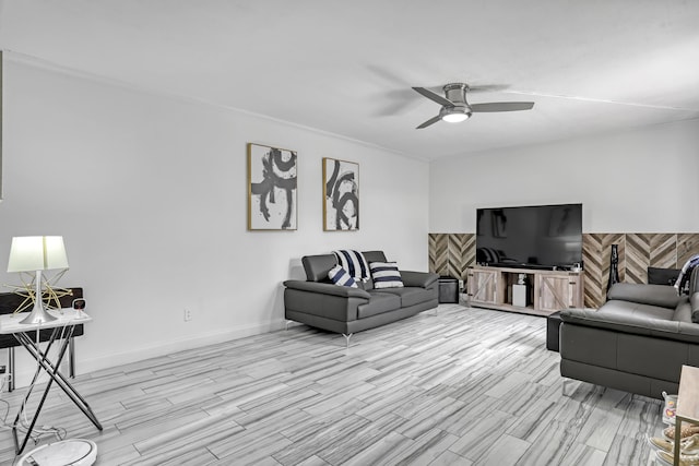 living area featuring a ceiling fan, light wood-style flooring, and baseboards