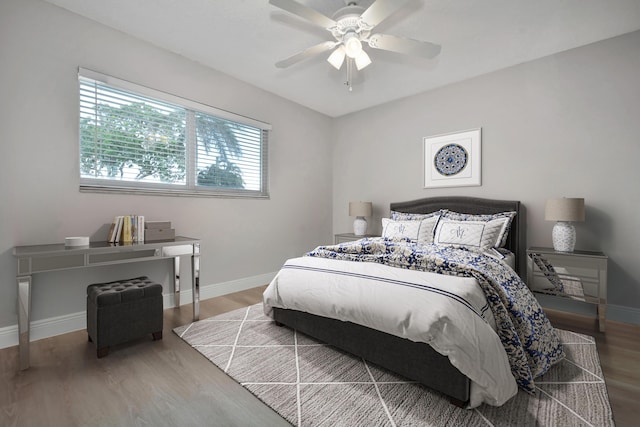 bedroom featuring wood finished floors, baseboards, and a ceiling fan