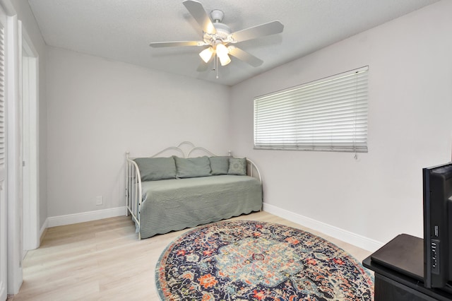 bedroom featuring wood finished floors, baseboards, and a ceiling fan