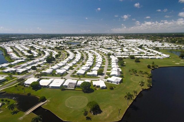 aerial view of property's location with nearby suburban area, a large body of water, and a golf course