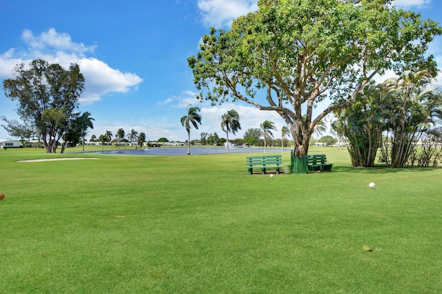 surrounding community with a yard, a water view, and golf course view