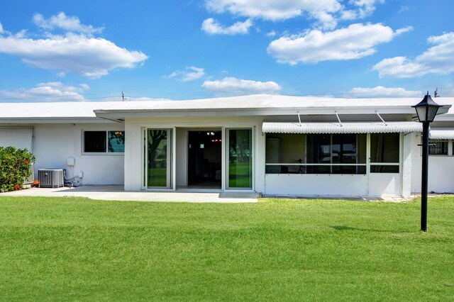 back of house featuring cooling unit, a yard, and stucco siding