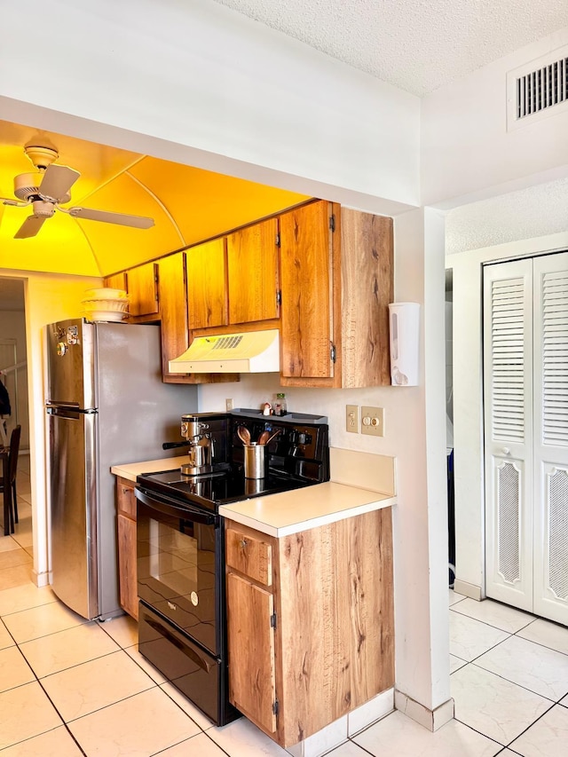8305 NW 61st St Unit C309, Tamarac, FL 33321 - kitchen with black / electric stove, under cabinet range hood, light countertops, light tile patterned flooring, and brown cabinetry