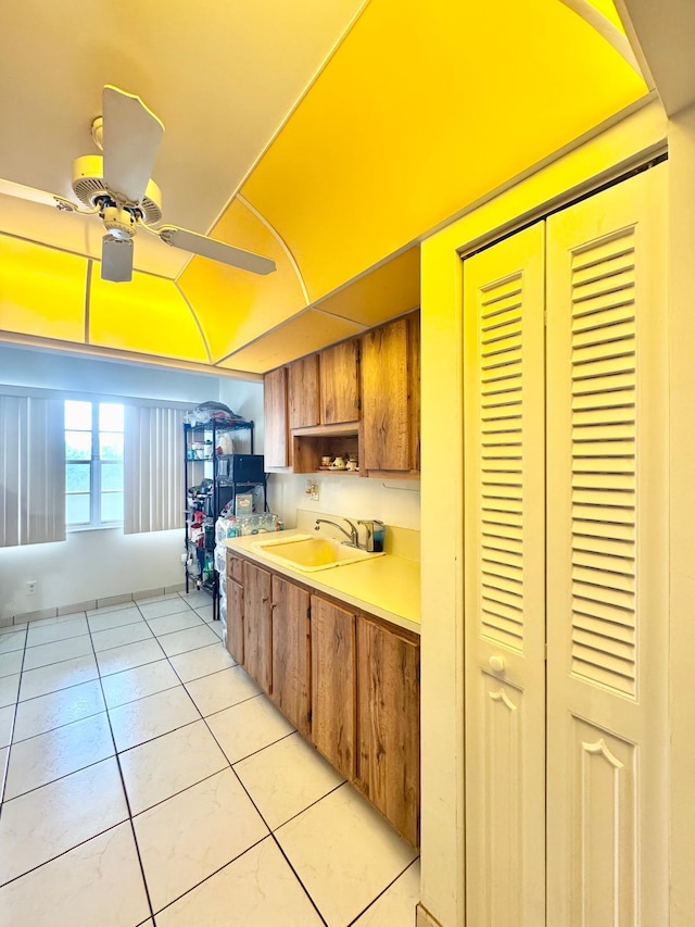 8305 NW 61st St Unit C309, Tamarac, FL 33321 - kitchen featuring a sink, light tile patterned floors, brown cabinets, light countertops, and a ceiling fan