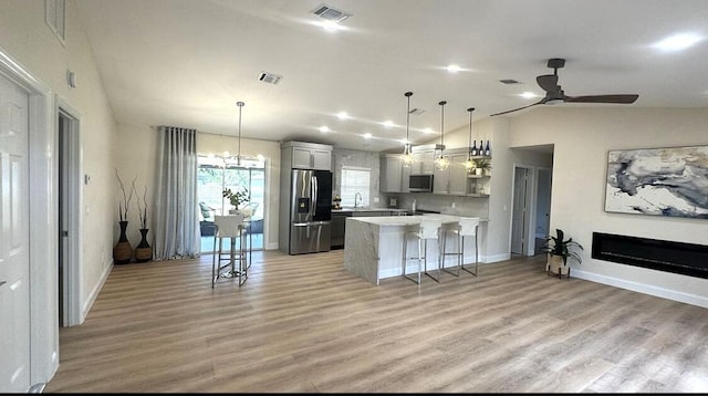 kitchen featuring stainless steel appliances, lofted ceiling, a peninsula, light countertops, and ceiling fan