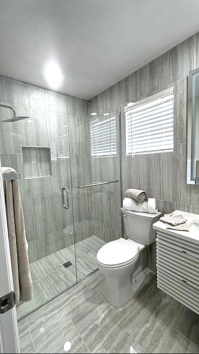full bath with toilet, a shower stall, and vanity