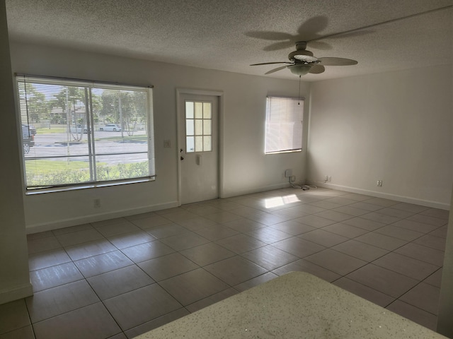 3587 La Playas Ct Unit A-1, Greenacres, FL 33463 - tiled spare room with a ceiling fan, a textured ceiling, and baseboards