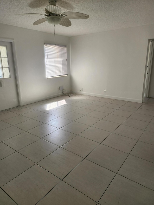 3587 La Playas Ct Unit A-1, Greenacres, FL 33463 - empty room with a textured ceiling, healthy amount of natural light, a ceiling fan, and light tile patterned floors
