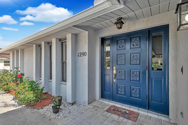 1290 SE Mcfarlane Ave, Port Saint Lucie, FL 34952 - doorway to property featuring stucco siding and covered porch
