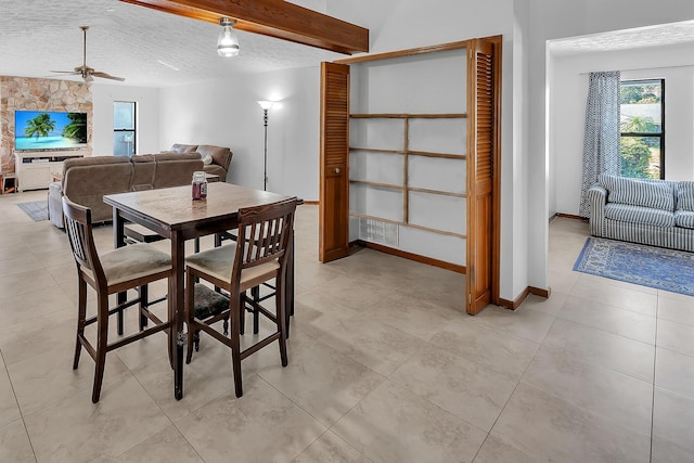 1290 SE Mcfarlane Ave, Port Saint Lucie, FL 34952 - dining area featuring a textured ceiling, ceiling fan, baseboards, and light tile patterned flooring