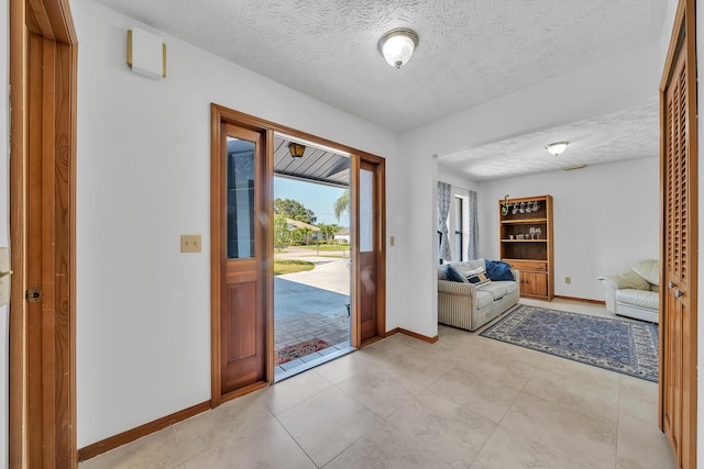1290 SE Mcfarlane Ave, Port Saint Lucie, FL 34952 - foyer entrance featuring baseboards, a textured ceiling, and light tile patterned floors