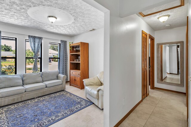1290 SE Mcfarlane Ave, Port Saint Lucie, FL 34952 - living area with a textured ceiling, baseboards, and light tile patterned flooring