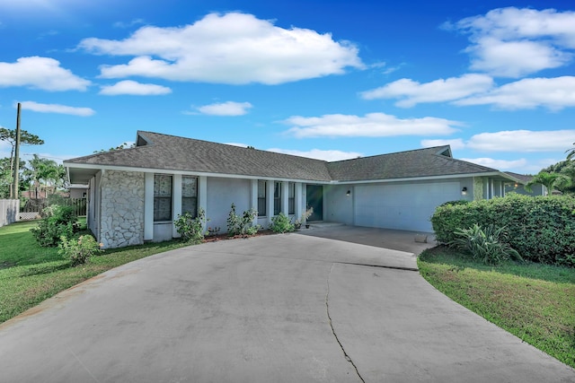 1290 SE Mcfarlane Ave, Port Saint Lucie, FL 34952 - ranch-style home with an attached garage, concrete driveway, a front yard, stone siding, and stucco siding