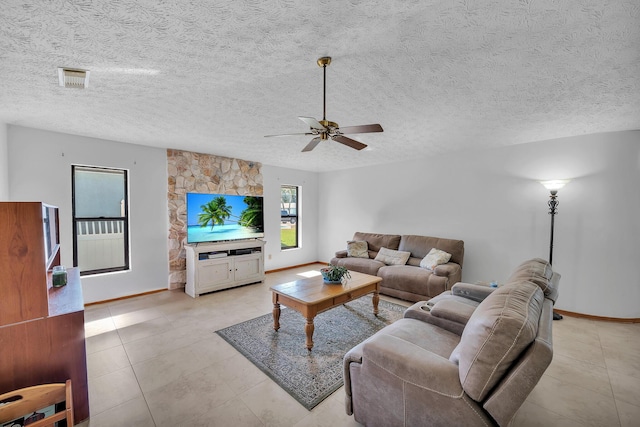 1290 SE Mcfarlane Ave, Port Saint Lucie, FL 34952 - living room featuring baseboards, light tile patterned flooring, ceiling fan, and a textured ceiling